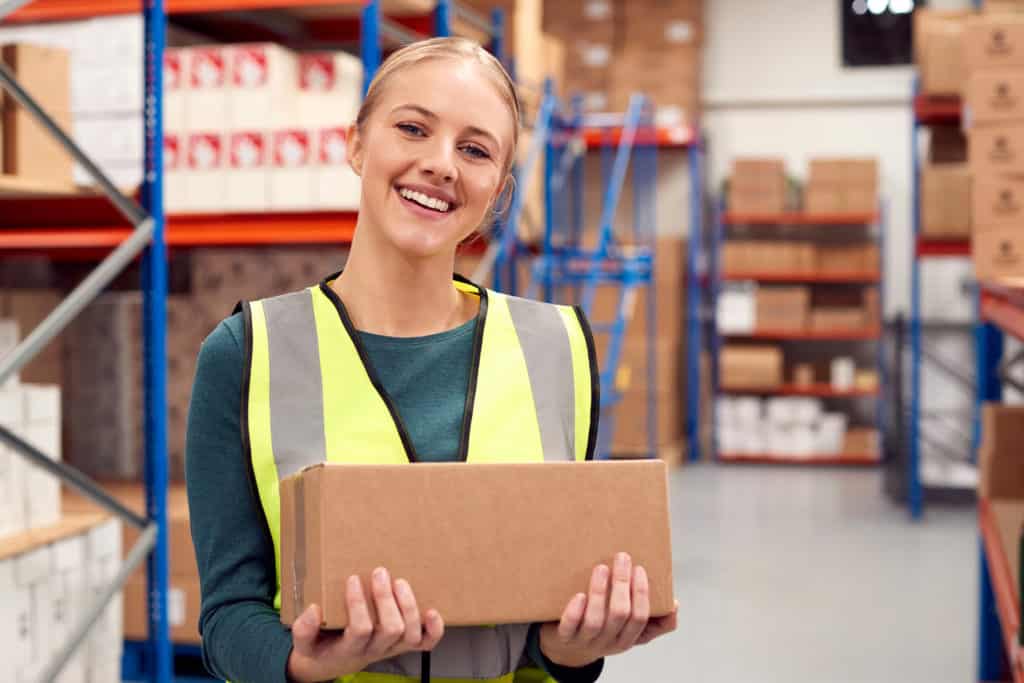 Female Worker Holding Box Inside Warehouse